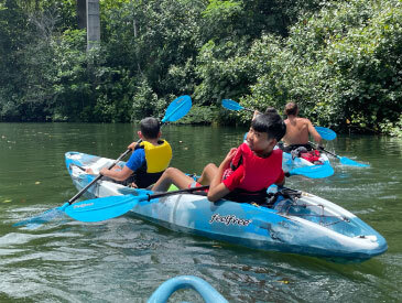 kids kayaking in a blue kayak